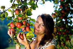 Young woman under an apple tree, Styria, Austria