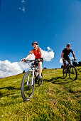 Zwei Mountainbiker fahren über Bergwiese, Duisitzkar, Planai, Steiermark, Österreich