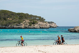 Cyclists on the beach, Cala Mondrago, near Santanyi, Majorca, Spain