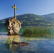 Cross on a rock, Lake Mondsee with Hoeblingkogel, Salzkammergut, Salzburg Land, Austria