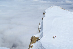 Zwei Personen auf Skitour stehen an Schneegrat, Nebelmeer im Tal, Skitour, Monte Camicia, Val Vradda, Gran Sasso, Calascio, Abruzzen, Apenninen, l 'Aquila, Italien