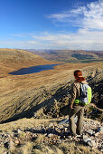 Frau beim Wandern blickt auf See Half Way Loch, Ben Nevis, Highlands, Schottland, Großbritannien
