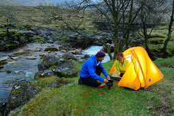 Paar kocht vor einem Zelt, Glen Etive, Buachaille Etive Mor, Highlands, Schottland, Großbritannien