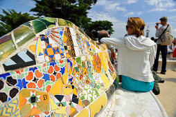 People sitting on mosaic serpent bench, Park Guell, architect Antoni Gaudi, UNESCO World Heritage Site Park Guell, Catalan modernista architecture, Art Nouveau, Barcelona, Catalonia, Spain