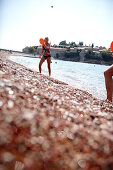 Couple playing beach ball at beach, Sveti Stefan, Budva, Montenegro