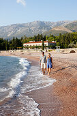 Paar am Strand, Villa Milocer im Hintergrund, Aman Sveti Stefan, Sveti Stefan, Budva, Montenegro