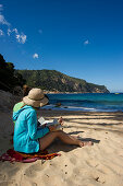 Two women reading on the beach, Aiguablava near Begur, Costa Brava, Spain