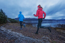 Junges Paar joggt am Loch Maree, Northwest Highlands im Hintergrund, Schottland, Großbritannien