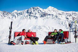 Skifahrer sonnen auf Sonnenboxen im Skigebiet, Bergstation Lavoz Bahn, Lenzerheide, Kanton Graubünden, Schweiz