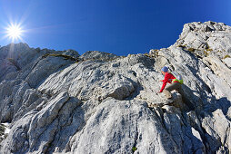 Frau klettert über Felsen zum Hochkalter, Nationalpark Berchtesgaden, Berchtesgadener Alpen, Oberbayern, Bayern, Deutschland