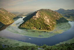 View of the river bend of the Rijeka Crnojevica river with boat, Lake Skadar National Park, Montenegro, Western Balkan, Europe