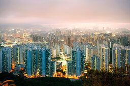 Cityscape with illuminated high-rise buildings in the evening, Hong Kong, China