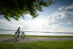 Mann fährt mit einem e-Bike am Starnberger See entlang, Oberbayer, Bayern, Deutschland