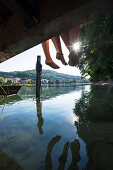 Two young women sitting on a jetty at river Rhine, Rheinfelden, Baden-Wuerttemberg, Germany