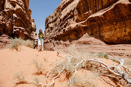 Woman hiking through a gorge, Wadi Rum, Jordan, Middle East