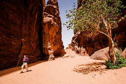 Frau wandert durch eine Felsenschlucht, Wadi Rum, Jordanien, Naher Osten