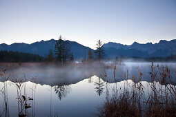 Morning mist, view over lake Barmsee to the Soiern mountains and Karwendel mountains, near Mittenwald, Bavaria, Germany