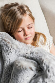 Girl sleeping under a fur blanket, Hamburg, Germany