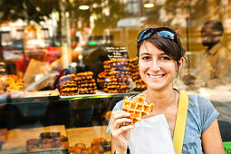 Woman eating a Belgian waffle, Liege, Wallonia, Belgium