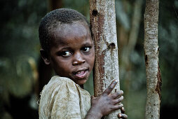 Junges Mädchen an einen Baum gelehnt, Uganda, Afrika