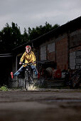 Woman riding an electric bicycle passing a puddle, Tanna, Thuringia, Germany