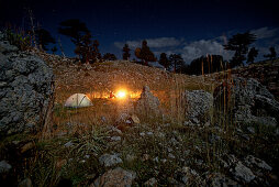 Woman sitting at a campfire in the evening, long-distance footpath Lycian Way, Antalya, Turkey
