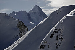 Freeskier steht auf einem Berggipfel, Chandolin, Kanton Wallis, Schweiz