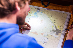 Skipper plant Route auf einer Seekarte an Board von einem Segelboot, Pula, Istrien, Kroatien