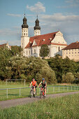 Cyclists, Marchtal Abbey in background, Obermarchtal, Baden-Wuerttemberg, Germany