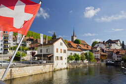 Swiss flag in the center of Vallorbe, Orbe river, Waadt, Switzerland