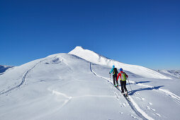 Two female back-country skiers ascending to mount Steinberg, Kitzbuehel Alps, Tyrol, Austria