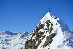 Female back-country skier standing on summit of Aeusseres Hocheck, Pflersch valley, Stubai Alps, South Tyrol, Italy