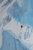 Mountaineer in a bergschrund of the north face of Monte Sarmiento, Cordillera Darwin, Tierra del Fuego, Chile