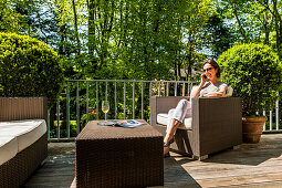 Woman making a phone call from a balcony, Hamburg, Germany