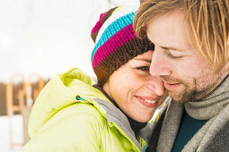 Mid adult couple embracing, woman wearing knit hat