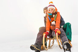 Couple on toboggan in snow