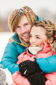 Mid adult couple embracing with snow in hair