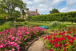 View from the rose garden across the lily pond to the manor house, Bateman's, home of the writer Rudyard Kipling, East Sussex, Great Britain
