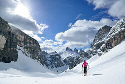 Frau auf Skitour steigt zum Hochebenkofel auf, Paternkofel, Schwabenalpenkopf und Drei Zinnen im Hintergrund, Sextener Dolomiten, Südtirol, Italien