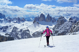 Female back-country skier ascending to Hochebenkofel, Sexten Dolomites, South Tyrol, Italy