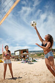 Frauen spielen Beachvolleyball nahe Water Sports Centre am Strand von Martinhal, Martinhal Beach Sagres, Algarve, Atlantikküste, Portugal, Südwestende Europas