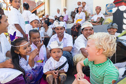 Balinese children playing with foreign boy, kids, making fun, making faces, temple ceremony, traditional dress, clothes, boy 3 years old, blond, intercultural contact, meeting local people, locals, family travel in Asia, parental leave, German, European, 