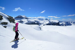 Female back-country skier looking to Sella Group with Piz Boe, Sella Group, Dolomites, South Tyrol, Italy