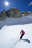 Female back-country skier downhill skiing through Val Pisciadu, Sella Group, Dolomites, South Tyrol, Italy