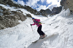 Female back-country skier downhill skiing through Val Setus, Sella Group, Dolomites, South Tyrol, Italy