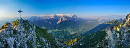 Hiker beside summit cross on Kramer, Ammergau Alps, Werdenfelser Land, Upper Bavaria, Bavaria, Germany