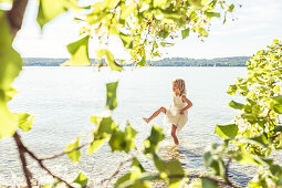 Mädchen im Sommerkleid steht im Starnberger See, Berg, Oberbayern, Bayern, Deutschland