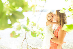 Mother carrying daughter in her arms, lake Starnberg, Berg, Upper Bavaria, Germany