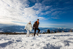 Paar mit einem Schlitten spaziert im Schnee, Zirbitzkogel, Mühlen, Steiermark, Österreich