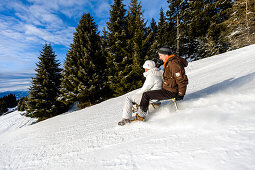 Couple downhill tobogganing, Muehlen, Styria, Austria